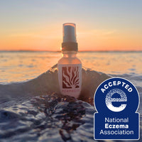 Bottle of Porphose product on a wave with a sunset background and National Eczema Association acceptance badge.